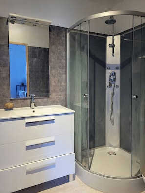 A modern bathroom with a glass-enclosed shower, a white vanity with drawers, and a large mirror. - Artist's house in the heart of Simiane-la-Rotonde (Simiane-la-Rotonde)