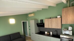 A compact kitchen with a dining area, a built-in oven, a microwave, and a sink. - Bellagio Lake Home (Bellagio)