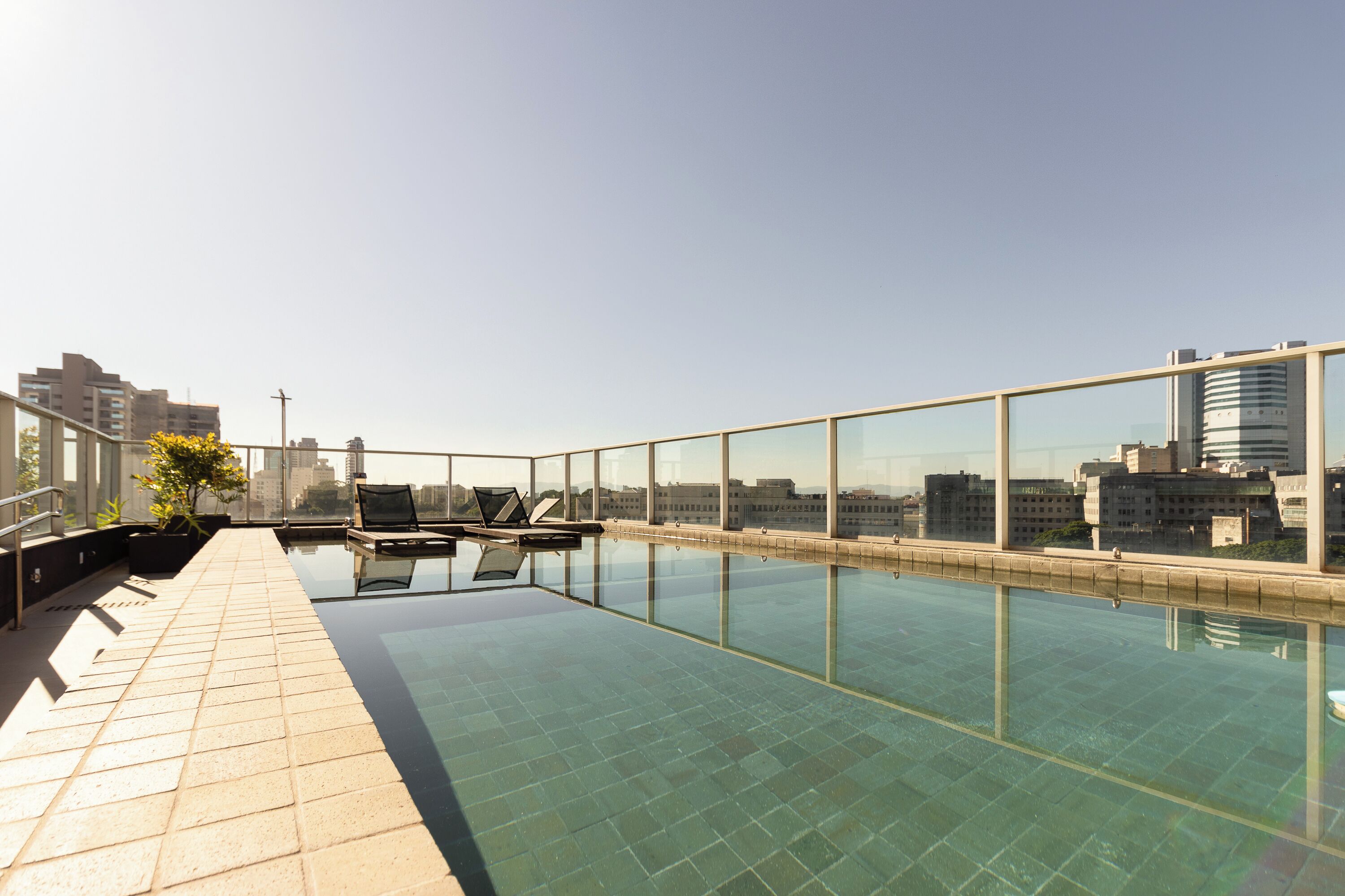 Una piscina al aire libre, sillones reclinables de piscina