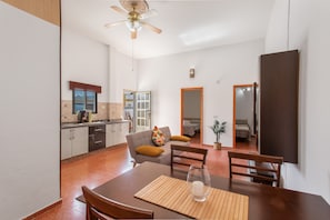 A modern kitchen with white cabinets, a dining area with a wooden table and chairs, and a ceiling fan. - Vacation Home 'Jomeca 2' with Mountain View, Shared Pool and Wi-Fi (San Bartolomé de Tirajana)