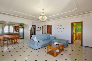 Ein Wohnzimmer mit einem blauen Sofa, einem Holztisch und einer Kandelaber.