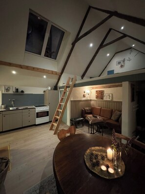 En bostad i loftstil med kök, matplats och sittgrupp.