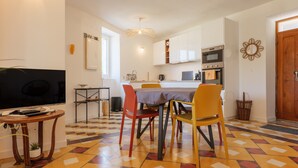 A dining area with a table, chairs, and a television. - Charming house in Vallon Pont d'Arc with private terrace, garden, and Wi-Fi (Vallon-Pont-d'Arc)