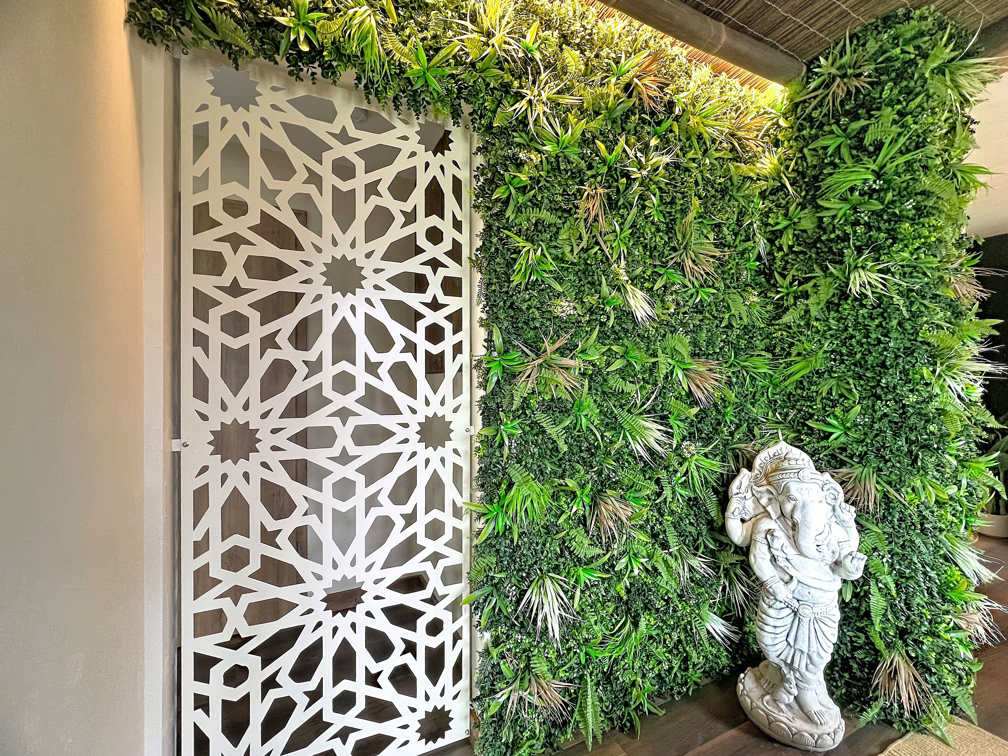 Un mur décoratif orné d’un motif géométrique et d’un feuillage verdoyant et luxuriant.