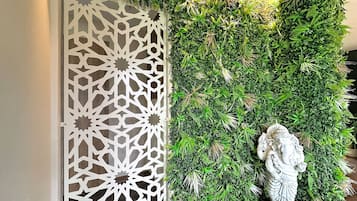Un mur décoratif orné d’un motif géométrique et d’un feuillage verdoyant et luxuriant.