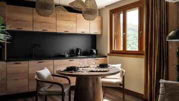 Une cuisine moderne avec des meubles en bois, une table à manger ronde et une fenêtre avec des rideaux.