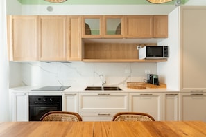 Una cucina con mobili in legno, un forno a microonde, un tostapane e un lavello.