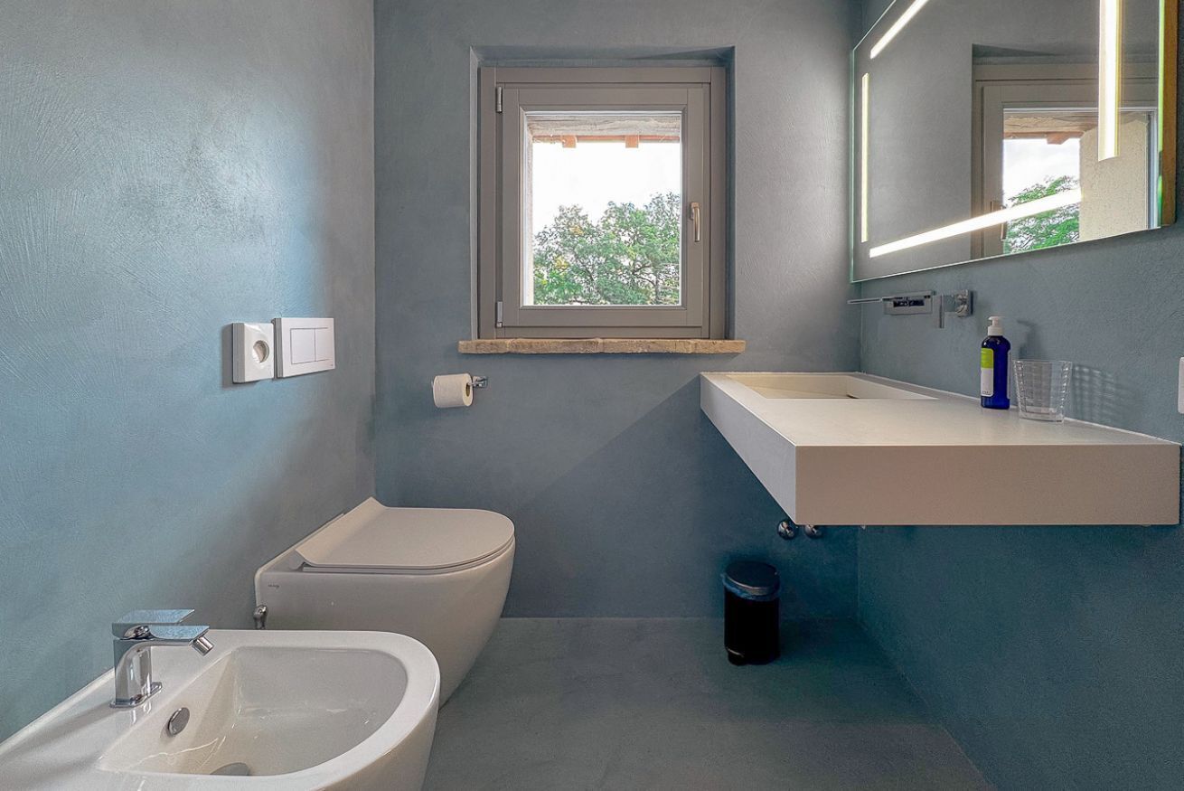 Un bagno con servizi igienici, bidet, lavandino e finestra.