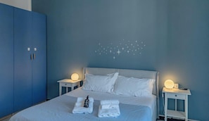 Une chambre à coucher comprenant un lit, deux tables de chevet, une armoire et un élément décoratif mural.