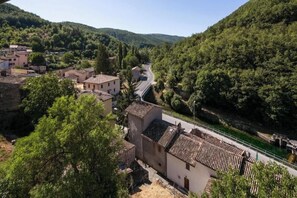 Un village rural avec des bâtiments traditionnels, une route sinueuse et une rivière.
