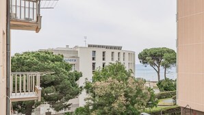 A building with a balcony, a tree, and a view of the sea. - [Sea Side] Beach 2 min • Free WiFi • Smart TV (Savona)