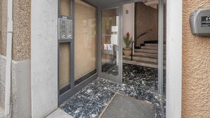 A hotel entrance with a glass door, a metal intercom, and a staircase leading inside. - [Sea Side] Beach 2 min • Free WiFi • Smart TV (Savona)