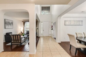 A spacious living area with a sofa, a dining table, and a kitchen in the background. - FS714 - Near The Star - Sleeps 8 - Parking - FS714 (Frisco)