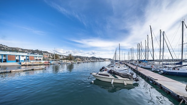 A marina with boats docked along the water, a building with a blue facade, and a clear sky. - [Stunning Residence] Marina & City view • A/C (Sanremo)