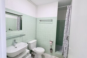 A bathroom with a sink, toilet, and shower area. - Getaway with an ocean view, balcony, and parking (Le Crotoy)