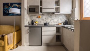 A compact kitchen with a microwave, a small refrigerator, and a sink. There is a painting on the wall and a floor lamp. - Dimora Camaldoli - Authentic Florence Experience (Firenze)