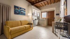 A compact living space with a sofa, kitchenette, and dining area. - Dimora Camaldoli - Authentic Florence Experience (Firenze)