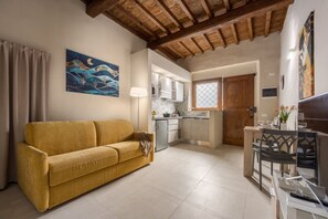 A compact living space with a sofa, kitchenette, and dining area. - Dimora Camaldoli - Authentic Florence Experience (Firenze)