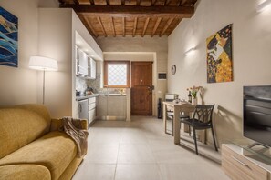 A modern kitchen with a wooden ceiling, a dining area with a table and chairs, and a sofa in a living area. - Dimora Camaldoli - Authentic Florence Experience (Firenze)
