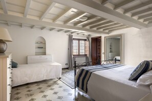 A bedroom with two beds, a wardrobe, a radiator, a mirror, and a window with curtains. - The Renaissance Chapel by Maison Florence (Florence)