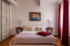 Ein Schlafzimmer mit einem Bett, einem Gemälde, zwei Nachttischen und einem Kleiderschrank.