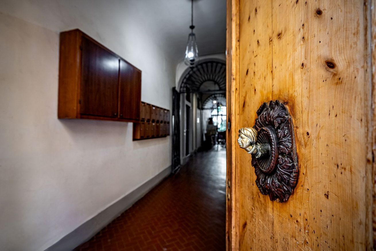 A hallway with wooden cabinets, a decorative door knocker, and a hanging light fixture.