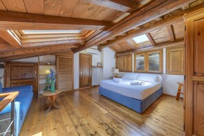 Un dormitorio tipo loft con cama, sofá y una mesita.