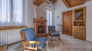 Un salon doté d’une cheminée, de meubles en bois et d’un sol carrelé.
