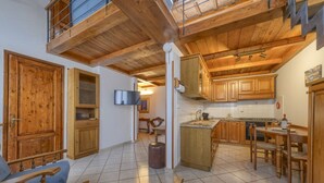Un vaste espace de vie agrémenté de meubles en bois, une cuisine avec des placards en bois et un balcon.