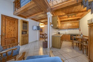 A spacious living area with wooden furniture, a kitchen with wooden cabinets, and a balcony. - Romantic Home - Charm and Elegance in the Heart of Florence (Firenze)