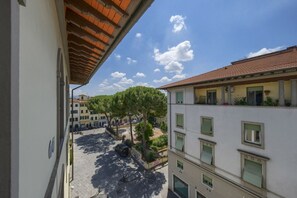 A courtyard with buildings, trees, and a clear sky. - Romantic Home - Charm and Elegance in the Heart of Florence (Firenze)