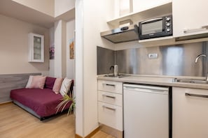 Eine kleine Küche mit Mikrowelle, Toaster und Geschirrspüler.