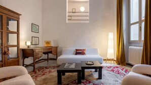 A room with a bed, a desk, a lamp, a radiator, and a window with curtains. - Like a Local Borgo San Jacopo By Maison Florence (Firenze)