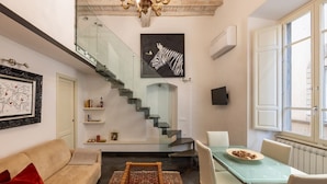 A modern interior with a staircase, a dining area, and a sofa. - Calimaruzza Apartment - by Maison Florence (Firenze)
