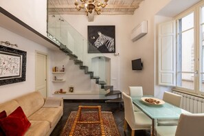 A modern interior with a staircase, a dining area, and a sofa. - Calimaruzza Apartment - by Maison Florence (Firenze)