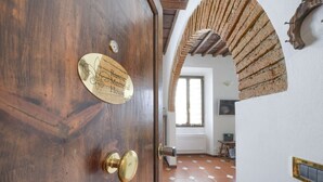 Une porte en bois, dotée d’une poignée en laiton et d’une plaque portant l’inscription « Maison rustique médiévale ».