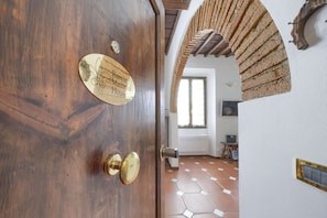 Eine Holztür mit Messingklinke und einer Tafel, auf der 'Rustic Medieval House' steht.