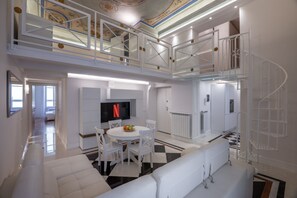 A spacious living area with a high ceiling, a staircase, and a flat-screen TV. - The White House - Home of the Frescoes (Firenze)