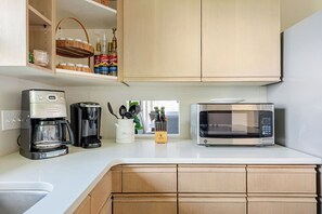 A kitchen with a coffee maker, a microwave, and a shelf with kitchen items. - Welcome to Skyline Point ~ Louisville Skyline (Floyds Knobs)