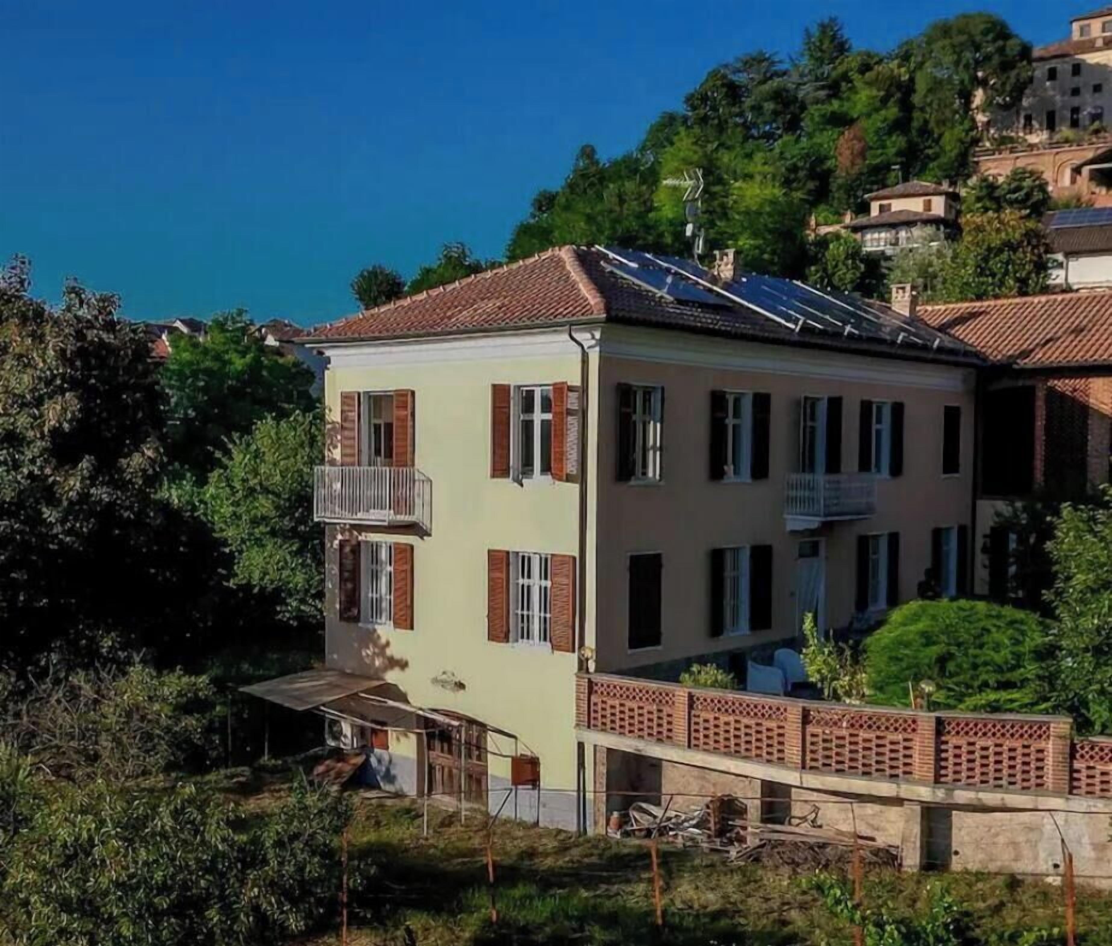 Un immeuble de deux étages doté d’un balcon, de panneaux solaires et offrant une vue sur la mer.