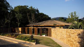 A modern hotel with a stone facade, wooden slats, and a tiled roof.