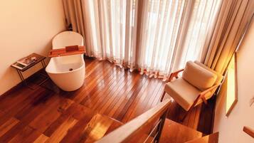 Um interior moderno com piso de madeira, vaso sanitário branco, sofá bege e escada.