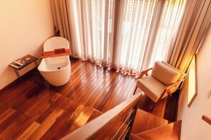 Een modern interieur met een houten vloer, een wit toilet, een beige bank en een trap.