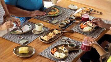 Mesa de jantar com diversos pratos e utensílios, indicando uma preparação para refeição.