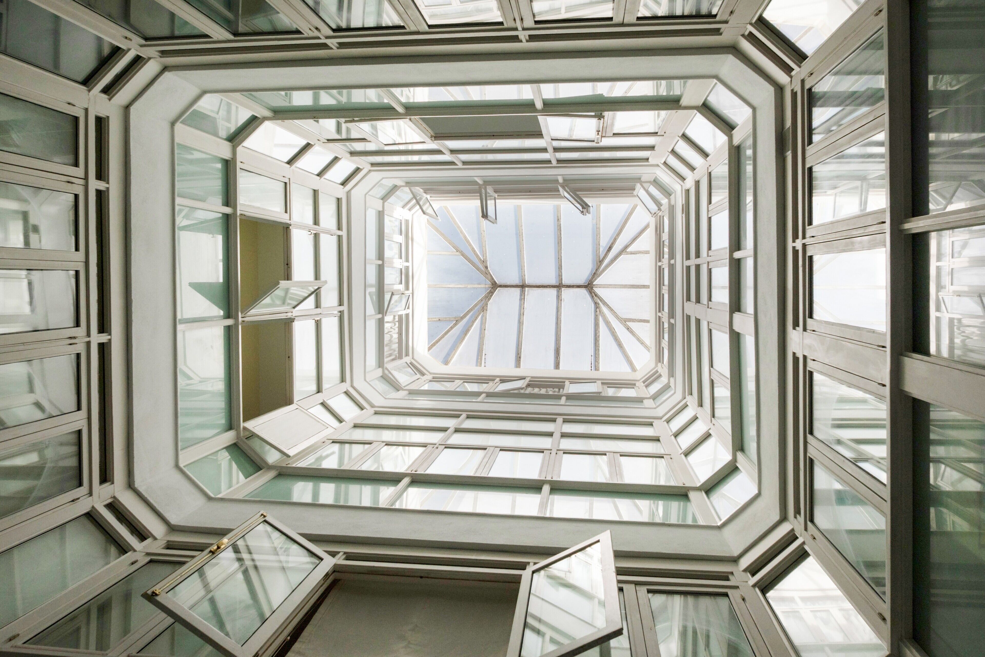 Een geometrische glazen dakconstructie met meerdere dakramen.
