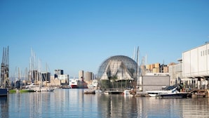 A marina with boats, a large transparent dome structure, and industrial buildings in the background. - [Comfort Suite] Airport 5 min • A/C • Smart TV (Genova)