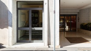 A building entrance with a glass door, a number '7' above it, and a small outdoor area with a mat. - GuestHost - Central Flat - Arno, Station and Duomo (Firenze)