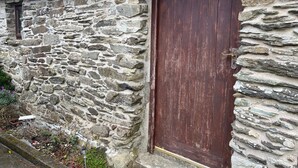 A stone building with a wooden door and a small window.