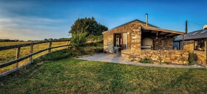 A stone building with a chimney, a wooden fence, and a grassy field. - Near to Durrus Cozy Apartment With a View (Dunbeacon)