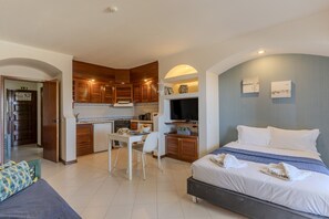 A compact hotel room with a bed, a small dining table, a kitchenette, and a TV. - #342 Cozy Studio in Belavista | Pool & Central (Albufeira)